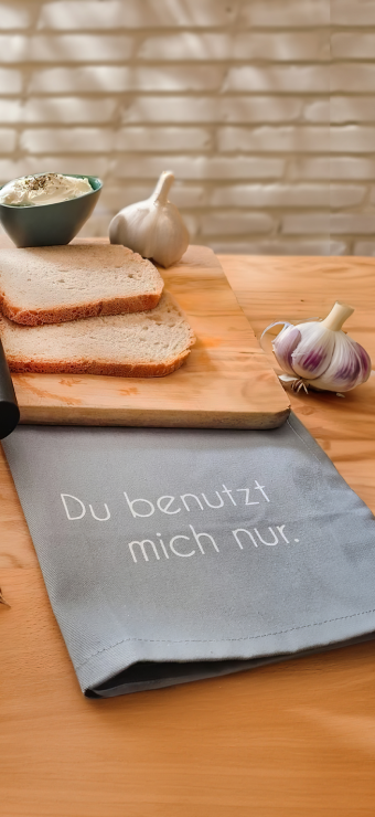 Towel on a table with garlic cloves and bread